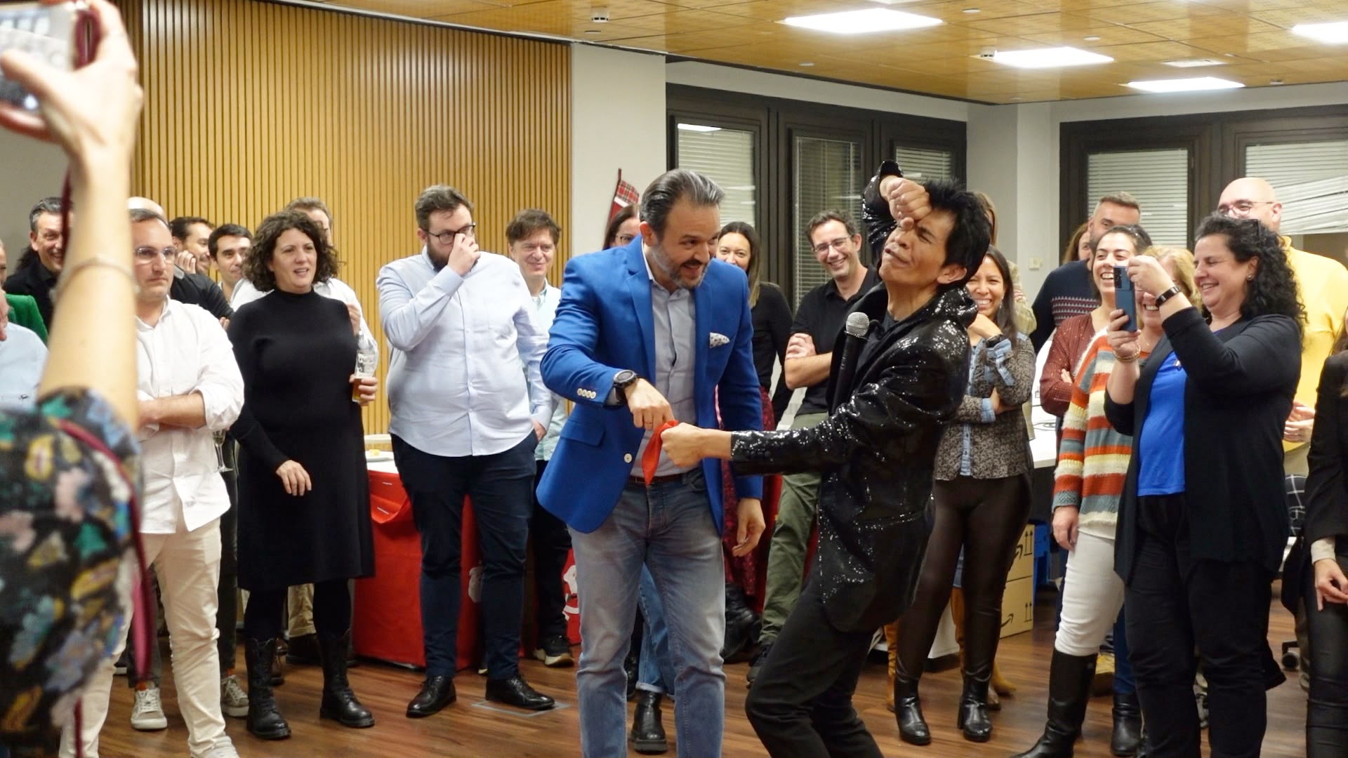 Mad Martin haciendo magia con un pañuelo rojo rodeado de público en un evento